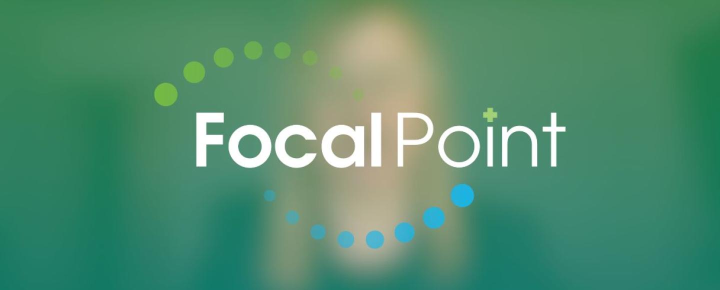 A blurred out, green screen capture from a video in the background with the Focal Point logo in white, green, and blue in the foreground